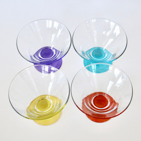 Four glass bowls with colorful bases on a white background