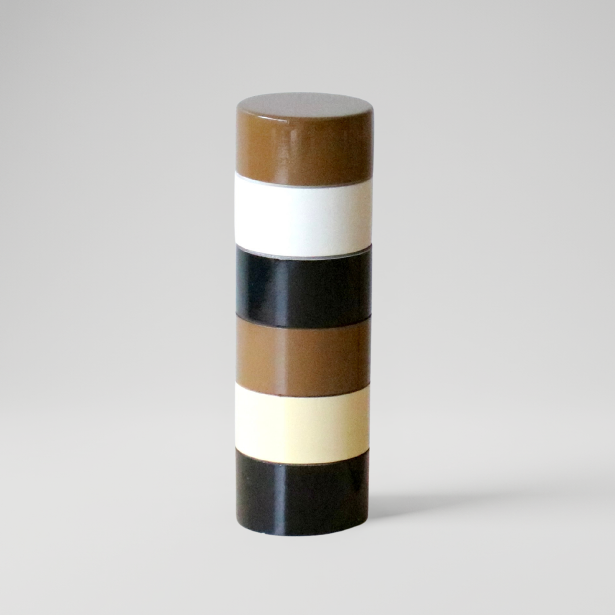 Cylindrical Semi D salt pepper grinder with striped pattern on a gray background