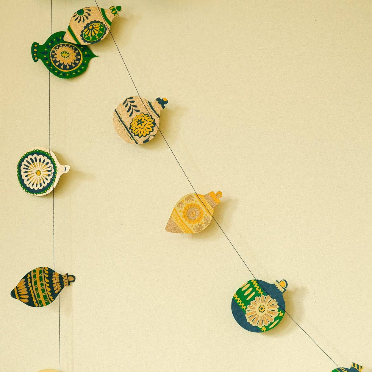 Decorative string with ceramic fish-shaped ornaments on a beige background