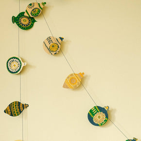 Decorative string with ceramic fish-shaped ornaments on a beige background
