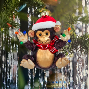 Monkey ornament wearing a Santa hat and scarf on a Christmas tree.