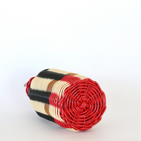 Decorative olive oil bottle with black, red and cream woven design and metallic nozzle on a white background