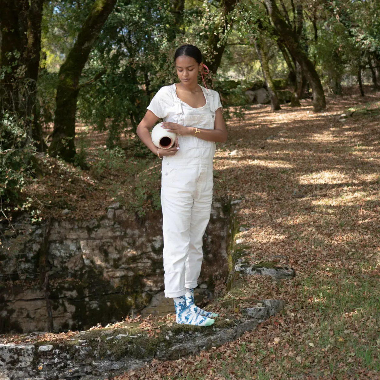 Woman in forest wearing white jeans wearing Bonne Maison Trompe L'oeil socks 