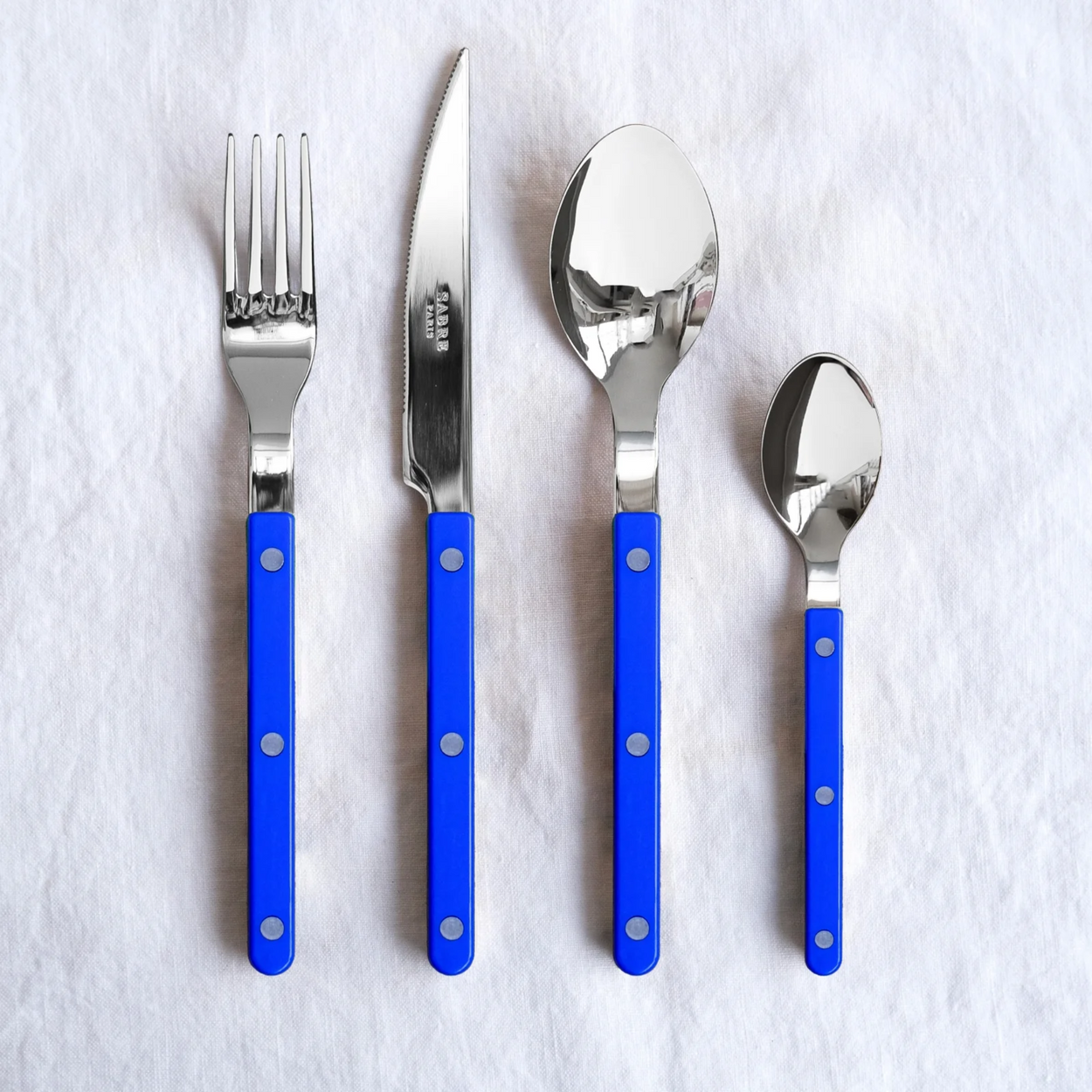 Sabre Bistrot Cutlery 4 Piece Set - Lapis Blue on white background.