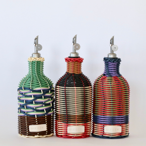 Group of three decorative olive oil bottle with woven design and metallic nozzle on a white background