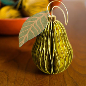 Decorative pear ornament with leaf on a wooden surface