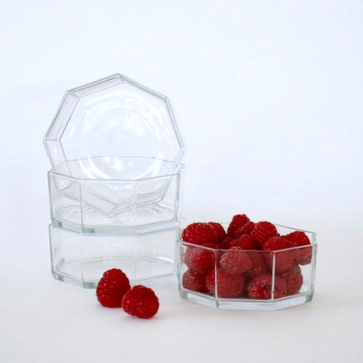 Hexagonal glass containers with raspberries on a white background