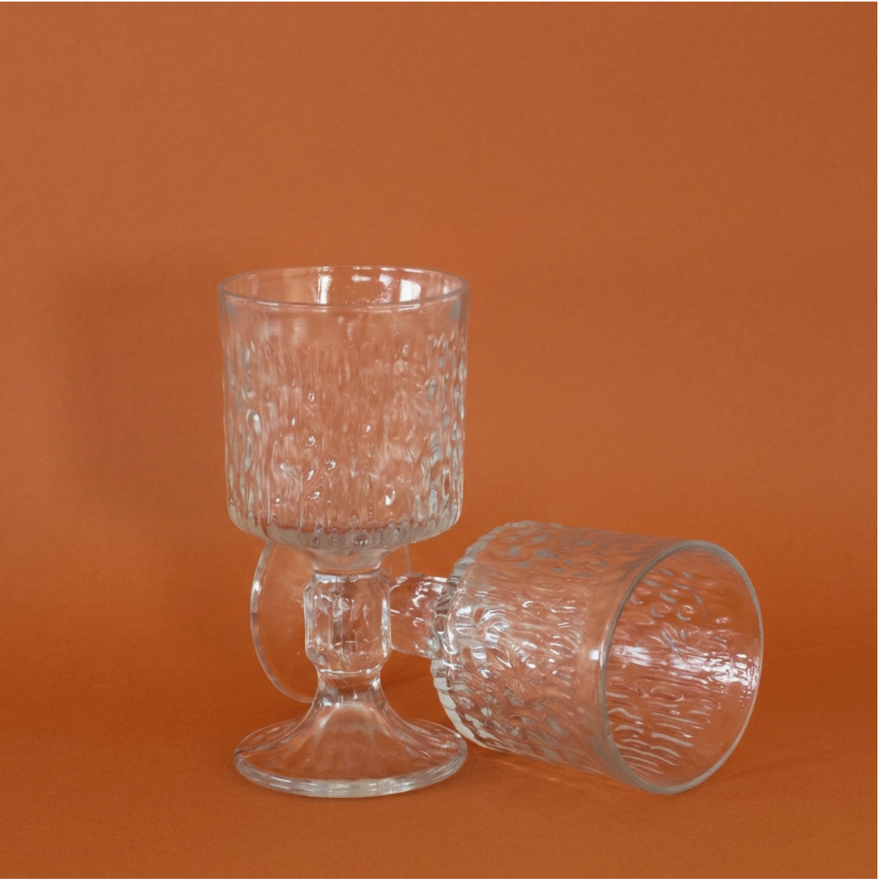 Ravenhead Icy Bark Siesta Wine glasses against a terracotta background.