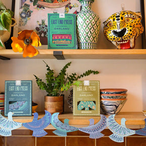 Shelf with decorative items including plants, books, and a clock.