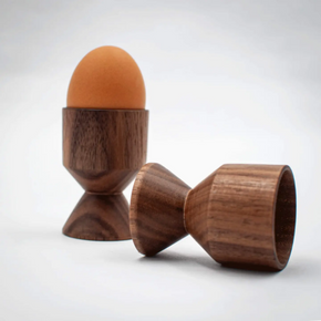 Wooden egg holder with an egg on a white background