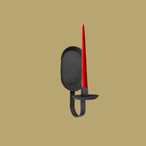 Black candle holder with a red candle on a beige background