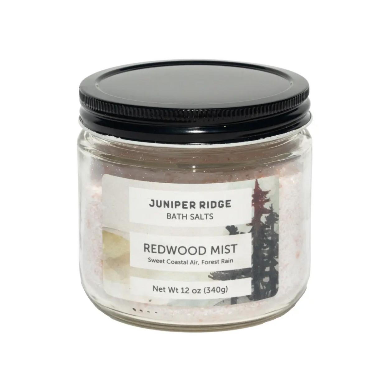 A 340g glass jar of Juniper Ridge Bath Salts in the Redwood Mist scent, featuring pinkish salt crystals inside and a black screw-on lid, shown on a plain white background.