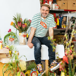 Florian Tanzer sitting among flowers and vases in a workshop setting