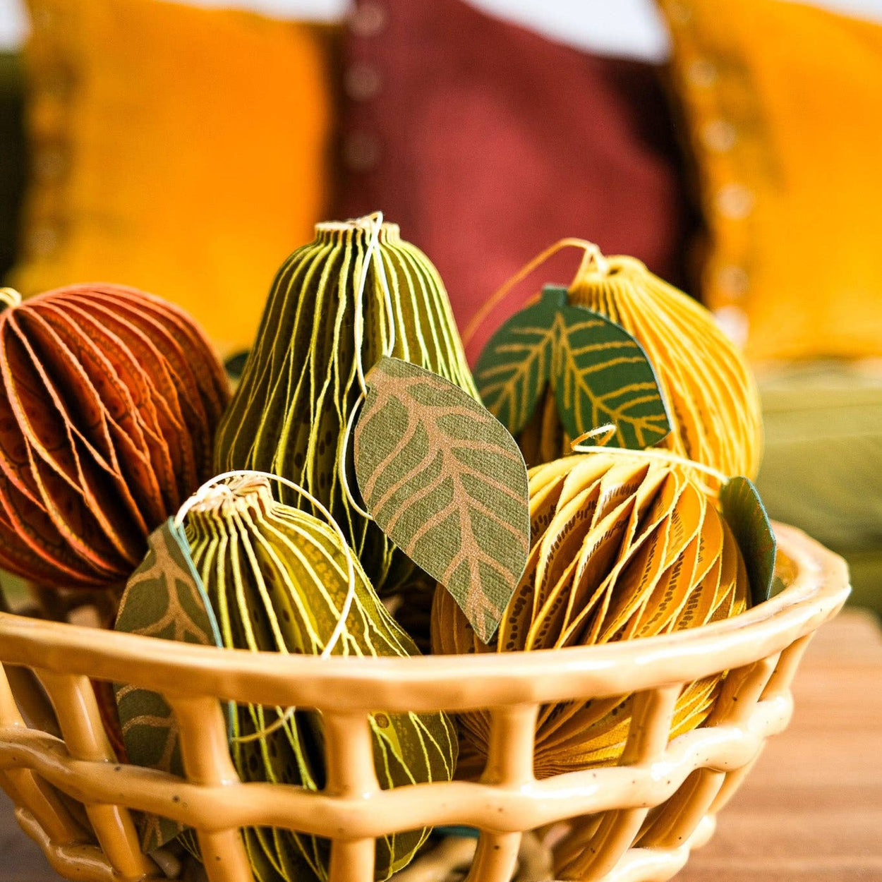 Decorative items in a woven basket with colorful pillows in the background