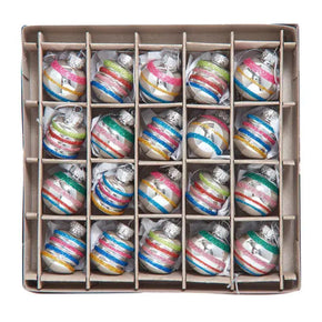 Box of multicolored striped Christmas ornaments on a white background