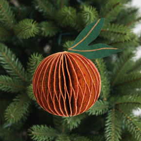 3D paper craft of a peach with green leaf on a Christmas tree foliage background