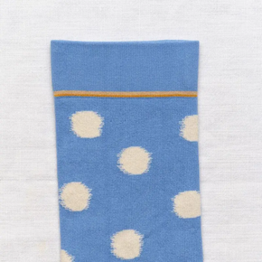 Close up of Bonne Maison pale blue polka dot socks on white backdrop.