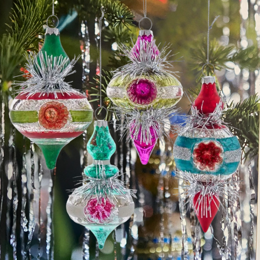 Colorful Christmas ornaments hanging on a tree with a blurred festive background