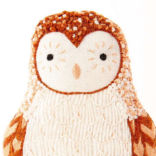 Textured owl figurine with brown and white colors on a white background