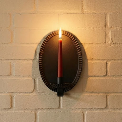 Wall-mounted iron candle sconce casting a warm glow on a brick wall