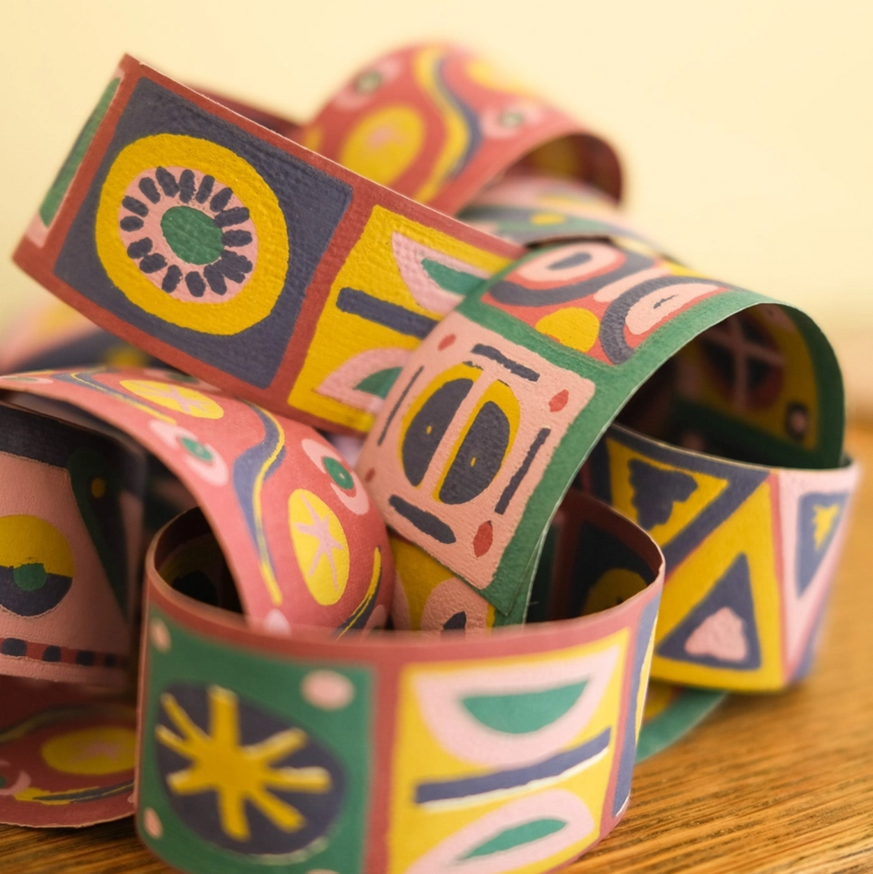 Colourful patterned paper chains on a wooden surface
