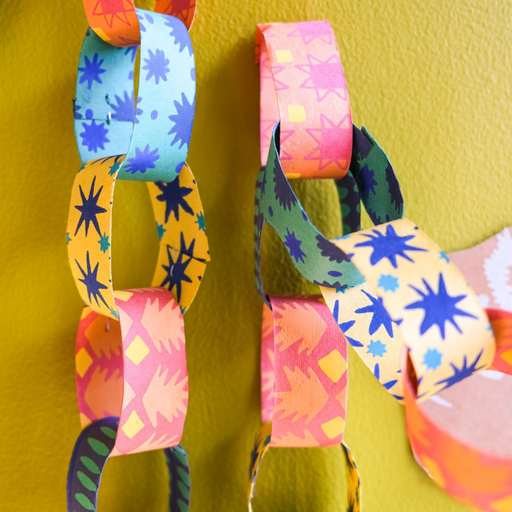 Colorful paper chain against a yellow wall