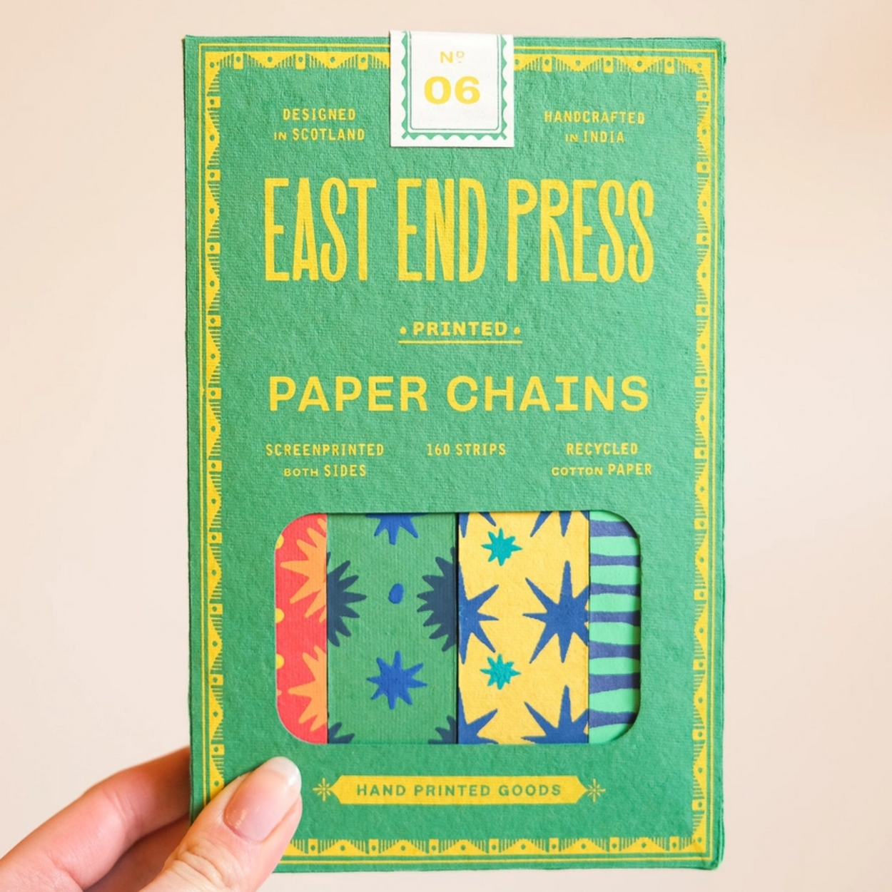Pack of East End Press paper chains held by a hand on a beige background