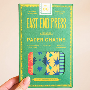 Pack of East End Press paper chains held by a hand on a beige background