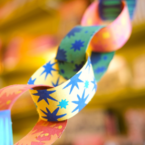 Colorful paper chain with star patterns against a blurred background