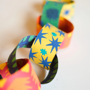 Colorful paper chains with star patterns on a light background
