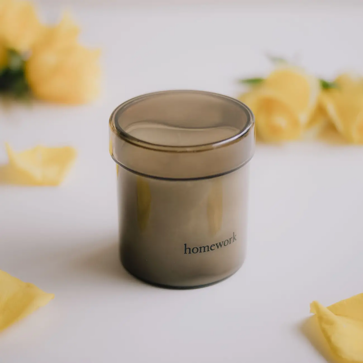 Earth scented candle surrounded by rose petals,by Homework UK.