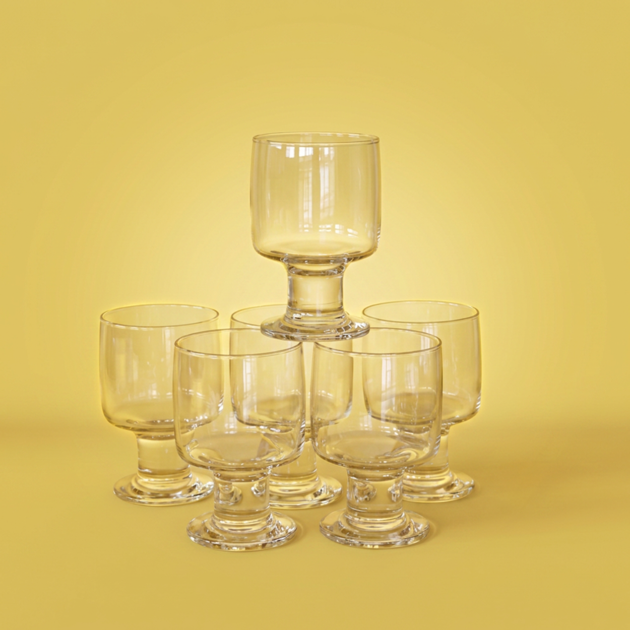 Set of 6 clear glass goblets on a yellow background