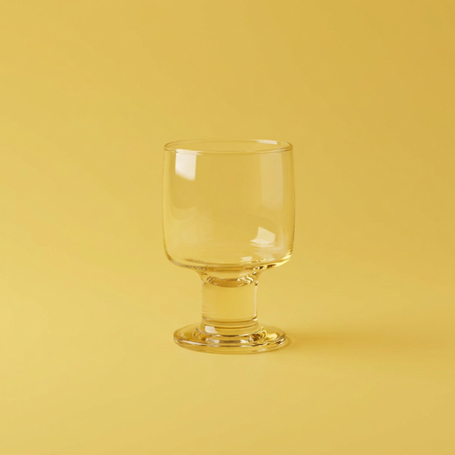 Clear glass goblet on a yellow background
