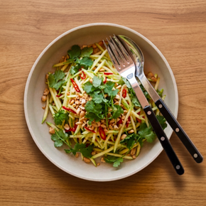 Sabre Bistrot Serving Set - Black in Thai salad bowl on wood table.