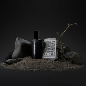 Fischersund Flotholt EDP Fragrance in still life with black rocks, twigs and Flotholt Discovery set