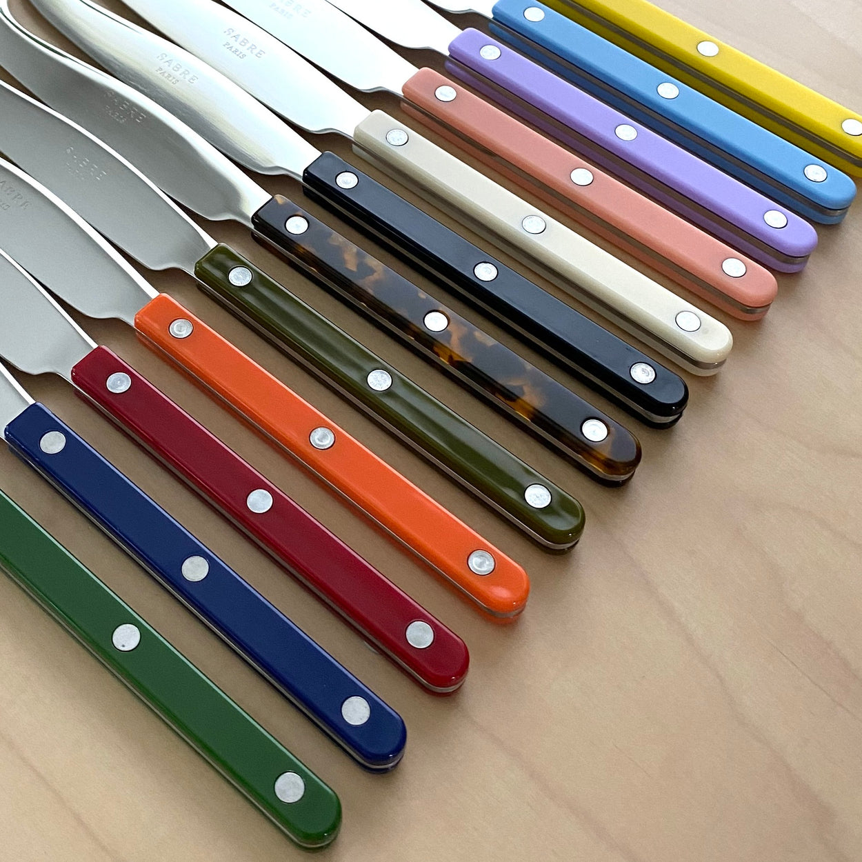 Close up of coloured handles of Sabre Paris Bistrot Rice Spoon