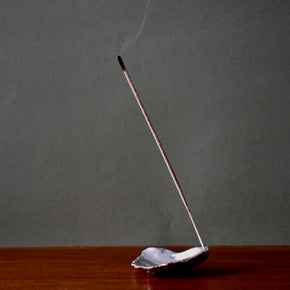 Silver oyster shell incense holder with alight incense stick