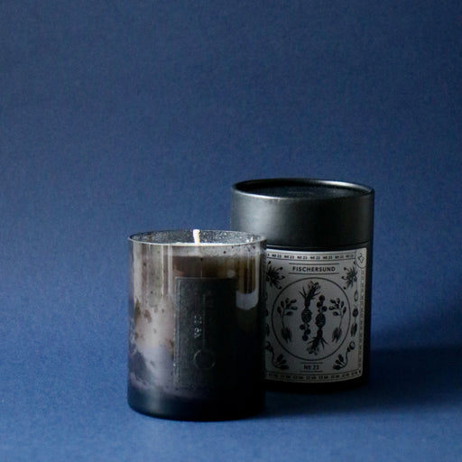 Fischersund No.23 candle with tube packaging against blue background.