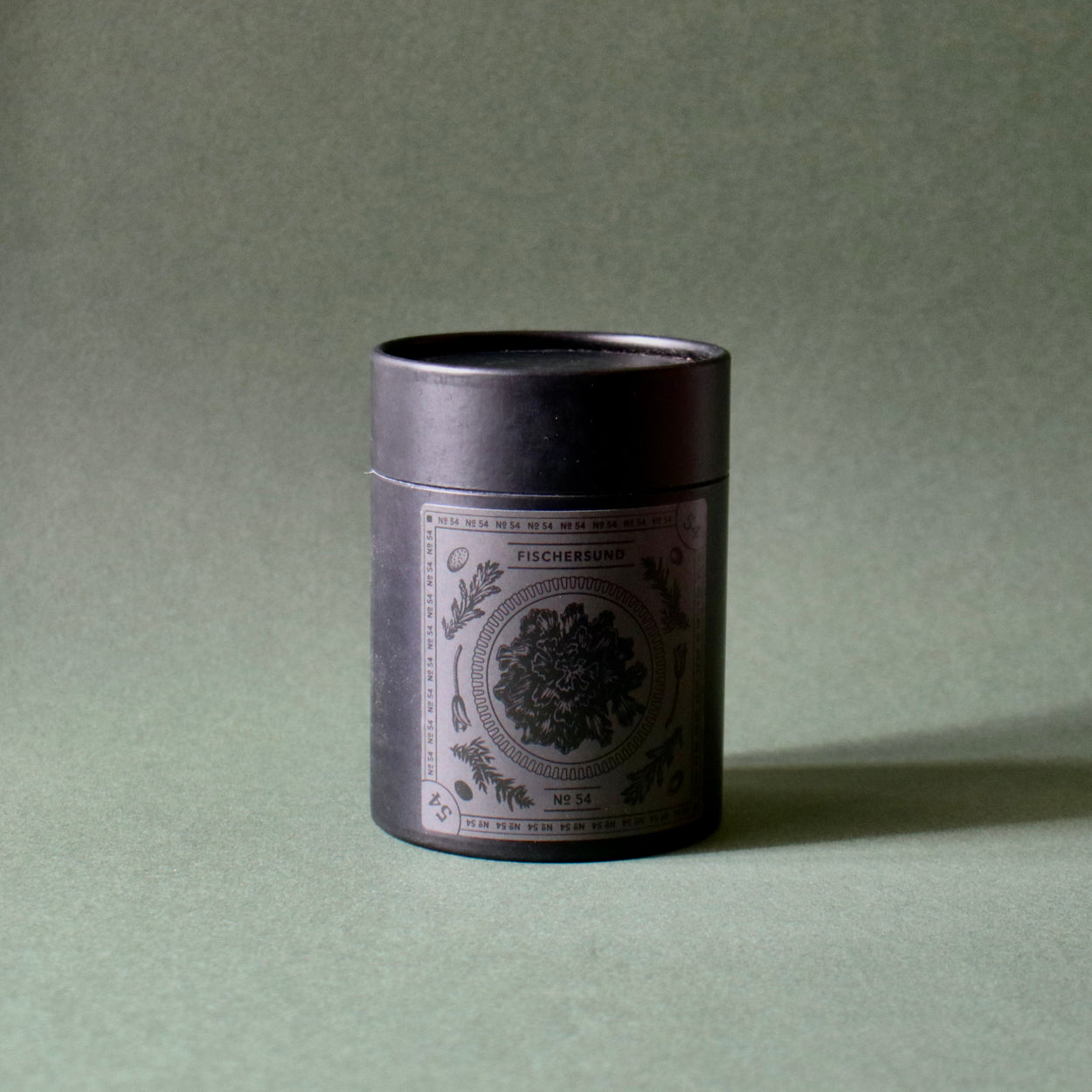 Fischersund No.54 candle with tube packaging against a green backdrop.