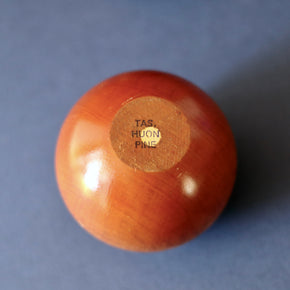 Vintage pair of hand made wooden apples against brown and green backdrop - close up of base.