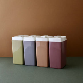 Vintage set of 4 Nylex Kitchen canisters against a brown and green backdrop.