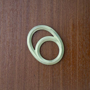 Futagami Eclipse Bottle Opener on dark wood background.