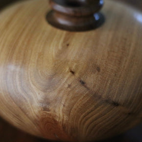 Close up of wood grain on Vintage wood turned vase on wood table.