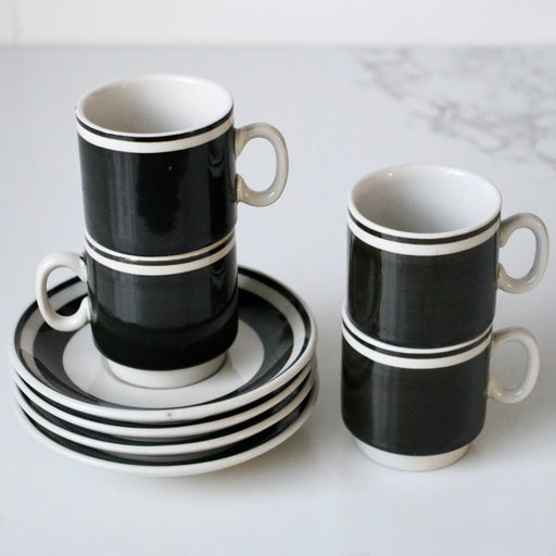 Liquorice black white espresso set with saucers on marble bench.