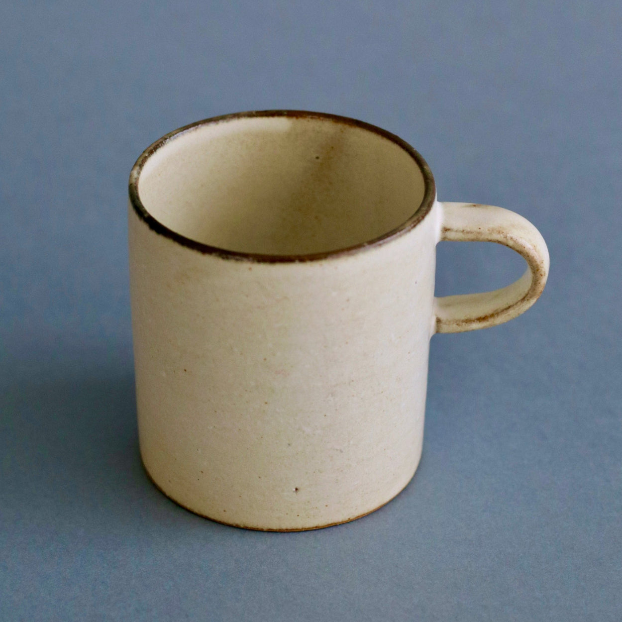 Japanese Ceramic Birch tall cup against blue backdrop.