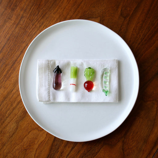 Vegetable Chopstick/Knife Rests on white plate on wood table