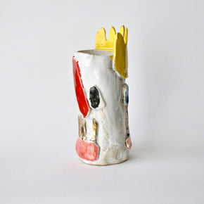 Ceramic vase with a yellow crown on a white background