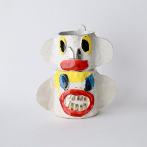 Ceramic vase with a face design on a white background