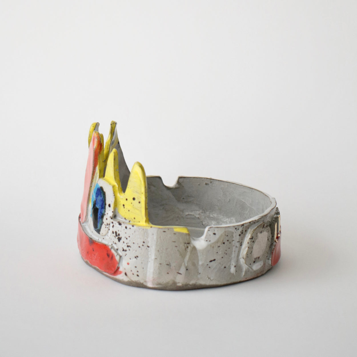 Ceramic bowl with colorful face design on a white background