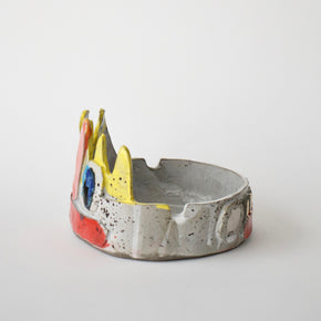 Ceramic bowl with colorful face design on a white background